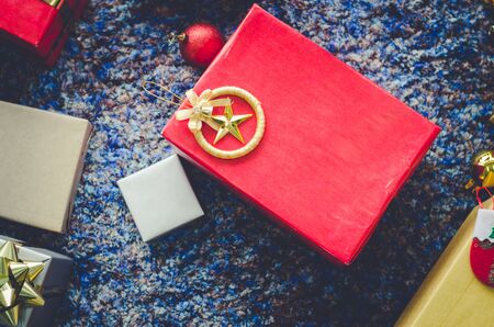golden gift box and red ribbon on color backgroundの写真素材