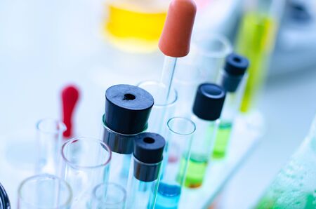 A pipette dropping sample into a test tube,abstract science backgroundの写真素材