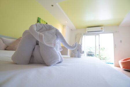 Bath towels on the bed of hotel bedroomの写真素材