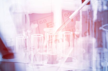 A pipette dropping sample into a test tube,abstract science backgroundの写真素材