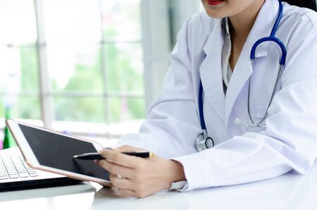 women long hair doctor holding tablet の写真素材