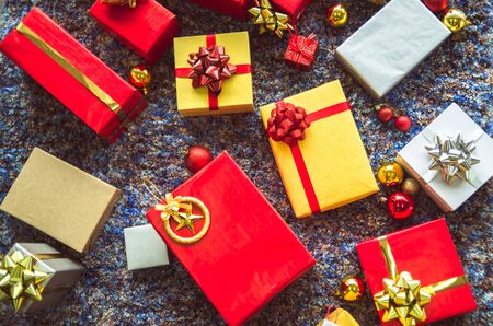 golden gift box and red ribbon on color backgroundの写真素材