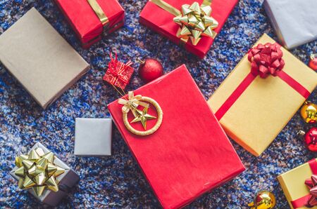 golden gift box and red ribbon on color backgroundの写真素材