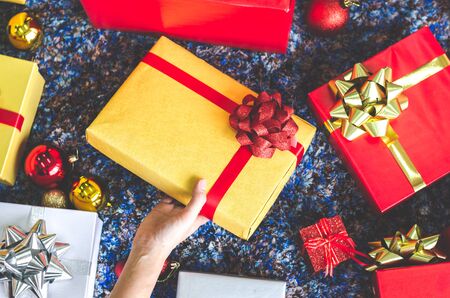 golden gift box and red ribbon on color backgroundの写真素材