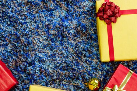 golden gift box and red ribbon on color backgroundの写真素材