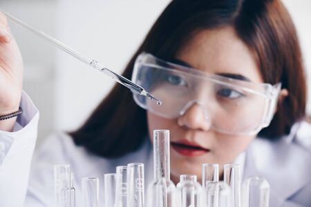 A pipette dropping sample into a test tube,abstract science backgroundの写真素材