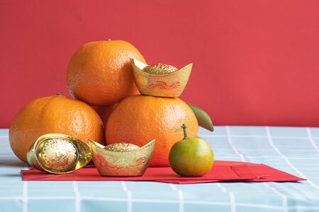 Accessories on Lunar New Year & Chinese New Year vacation concept background.Orange in white plate with red pocket moneyの写真素材