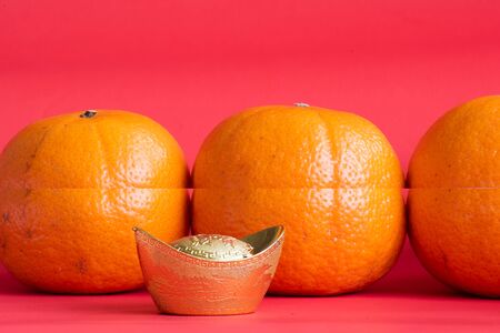 Accessories on Lunar New Year & Chinese New Year vacation concept background.Orange in white plate with red pocket moneyの写真素材