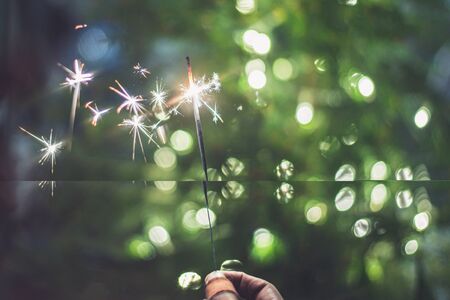 Christmas sparkler in girl hand の写真素材