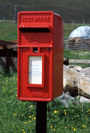 Red british letter box in countryside