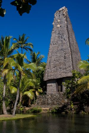 hut in polynesian village with coconut palm trees on waterfrontの写真素材