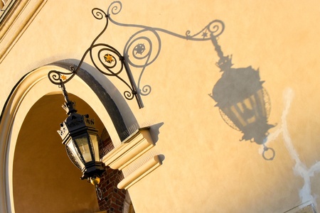 wrought-iron lantern  casts a shadow on a wall of Cloth Hall in Krakow, Polandの写真素材