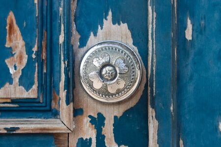 Silver metal door knob on an old wooden doorの写真素材
