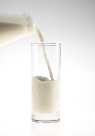 Bottle and Glass of Milk against White Backgroundの写真素材