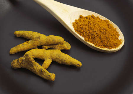 Root of Turmeric, curcuma longa, an Indian Spice against Black Background