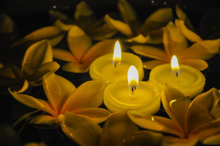 Floating lighted candles with Plumeriaの写真素材