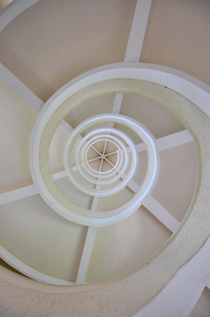 Under white spiral stairway, view from bottom up