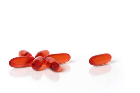 Translucent orange capsules isolated on white backgroundの写真素材