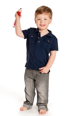 Cute boy holding a big pencil looking happy on a studio white background.の写真素材