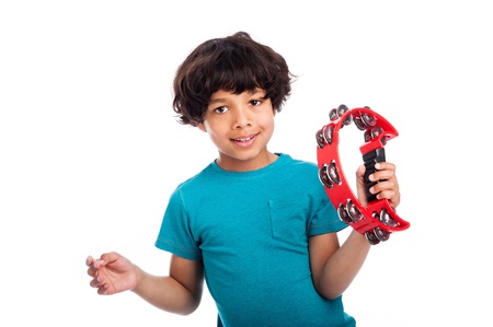 Cute mixed race kid playing a tambourine, isolated against white background.の写真素材