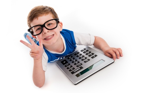 Toddler boy lying on the floor with a big calculator and holding up three fingers.の写真素材