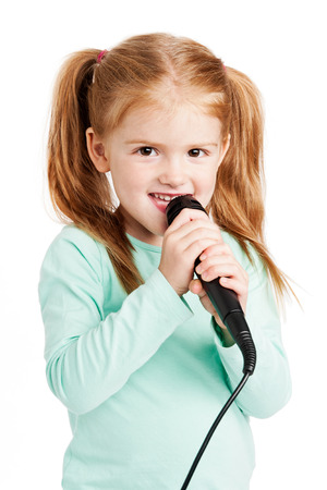 Cute three year old girl singimng with microphone.の写真素材