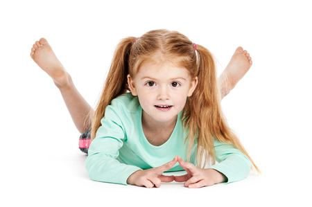 Beautiful little girl smiling to camera. Isolated on studio white background.の写真素材