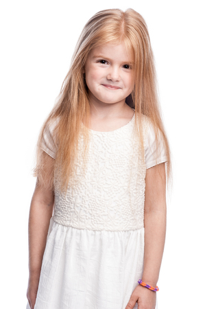 Portrait of a young girl smiling and embarressed. Studio shot on white background.の写真素材