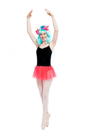 Smiling ballet girl in point position with arms up. Shot in studio on white background.の写真素材