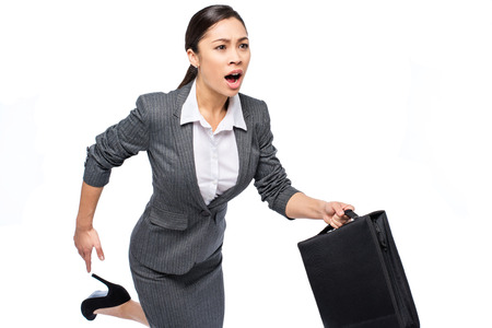 Beautiful Asian executive business woman running with a breifcase and calling out. Studio shot on white background.の写真素材
