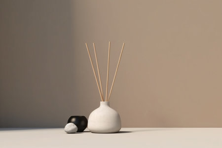 Serene image of reed diffuser illuminated by soft sunlight on table topの素材