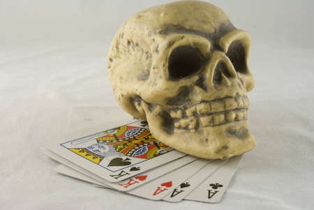 A skull resting on a full house aces over kings.