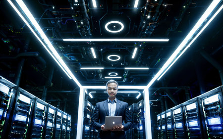 Businessman using laptop in a server room. Business and technology concept.の素材