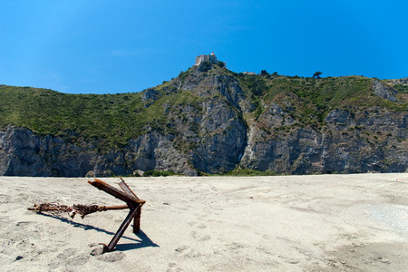 Old rusted anchor on the beach with Shrine of our Lady on background, Sicily, Italyの写真素材