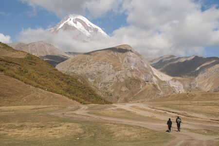 A pair of tourists on their way to the peak of Kazbek in Georgia