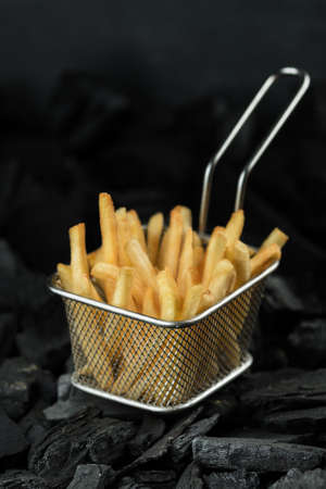 Fried potatoes in metal mesh, fast foodの写真素材