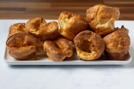 Yorkshire puddings viewed from the side stacked on a white trayの写真素材