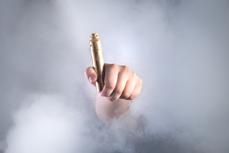 Man holding vaping device in smoke. Alternative to smoking cigarettesの写真素材