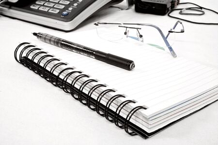 diary with pen, spectacles and phone
