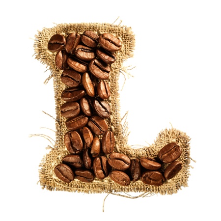 Alphabet from coffee beans on fabric texture isolated on white backgroundの写真素材