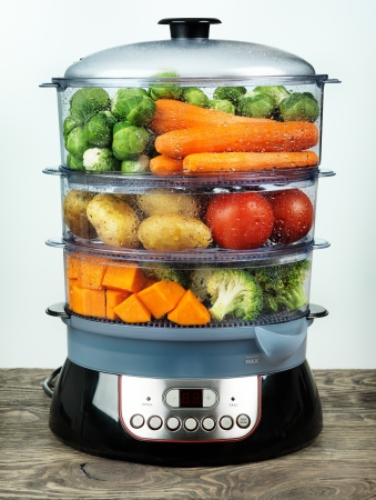 Healthy food in steamer, steam cooker with various vegetables and fruitsの写真素材