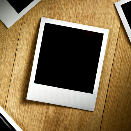 Polaroid fiilm vintage empty photo card on wooden backgroundの写真素材