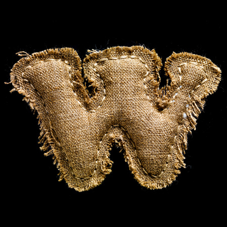 Linen or hemp vintage cloth letter W isolated on black backgroundの写真素材