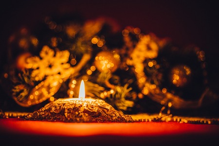 Christmas card with fir tree branch decorated with golden baubles, garlands and vintage snowflakes on a red background with copy space for your textの写真素材