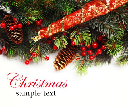 Christmas background. Christmas boarder with fir tree branch with cones and ornament. Christmas baubles in golden and red colour. Close up with copy space and sample text. Winter holidays concept.の写真素材