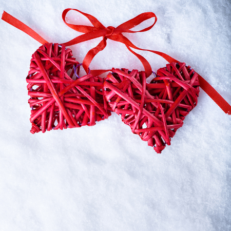 Two beautiful romantic vintage red hearts together on a white snow winter background. Love and St. Valentines Day concept.の写真素材