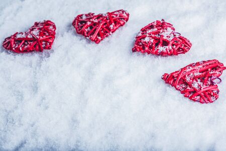 Four red hearts on a white snow winter background.の写真素材