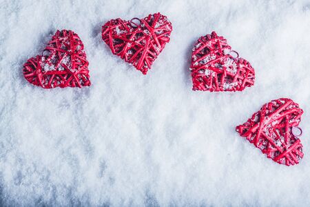 Four red hearts on a white snow winter background.の写真素材