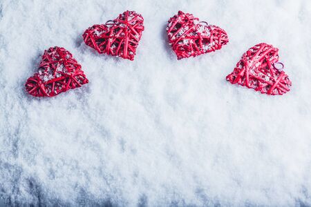 Four red hearts on a white snow winter background.の写真素材