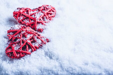 Two red hearts on a white snow winter background.の写真素材